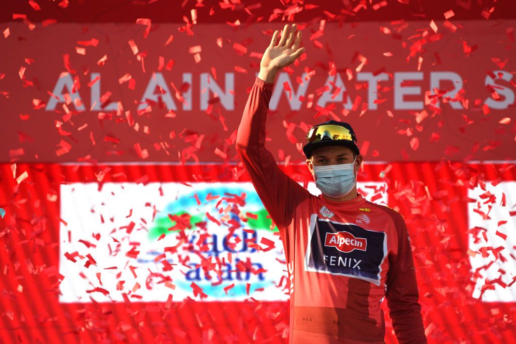 MADINAT ZAYED UNITED ARAB EMIRATES FEBRUARY 20 Jasper Philipsen of Belgium and Team AlpecinFenix celebrates at podium as Red Leader Jersey winner after the 4th UAE Tour 2022 Stage 1 a 184km stage from Madinat Zayed to Madinat Zayed UAETour WorldTour on February 20 2022 in Madinat Zayed United Arab Emirates Photo by Tim de WaeleGetty Images