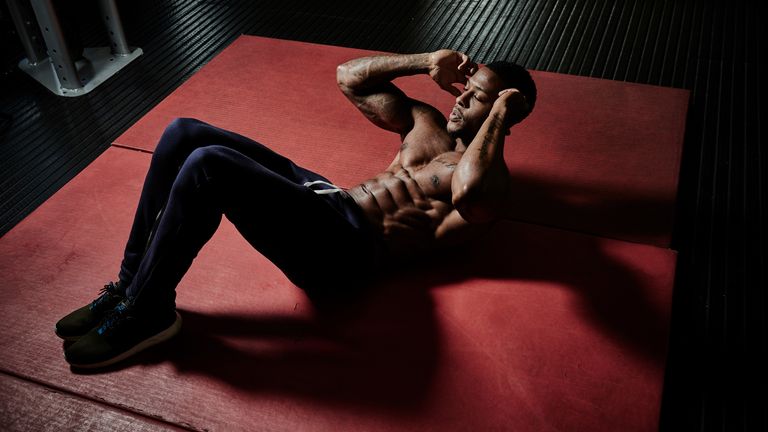 Man does a situp as he trains his abs and core