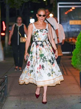 Jennifer Lopez walks in New York City wearing a floral dress and burgundy Gucci pumps