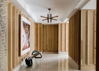 a wooden paneled entryway with terrazzo floor