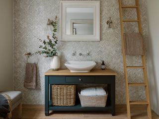 bathroom storage vanity with wooden countertop and ceramic basin