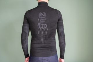 A cyclist wearing a Spatz Basez Extreme base layer facing a green wall