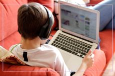 Young boy wearing headphones looking at a laptop