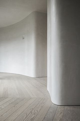 curved white walls around wooden flooring