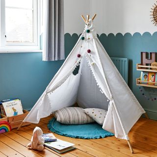 Child's bedroom with blue painted scallop-effect walls and white teepee