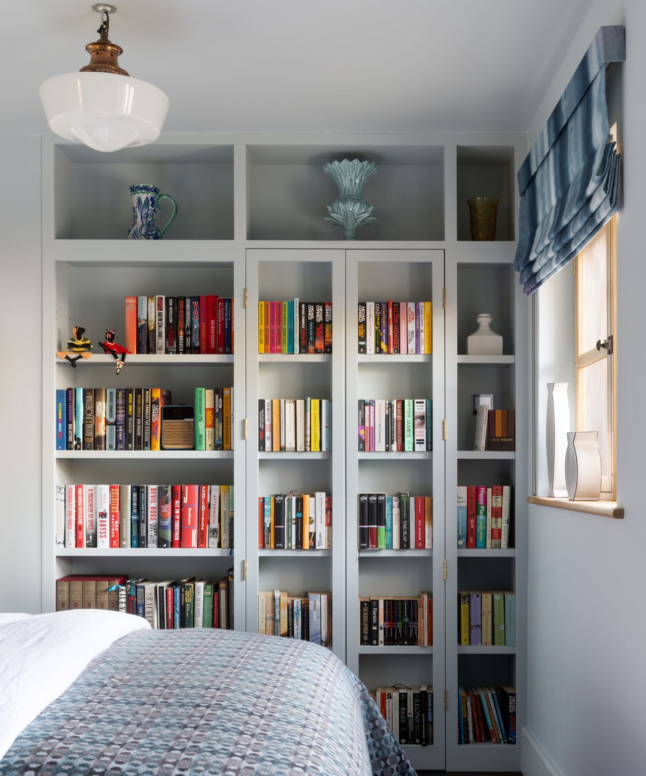 built in pale grey painted book shelving unit in bedroom concealing doors which open onto small ensuite idea