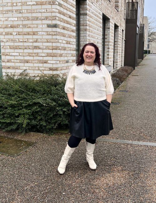 rivkie baum in a white jumper over a black dress