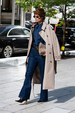 Woman wearing head-to-toe denim with a tan trench coat during New York Fashion Week on September 10, 2024 in New York City.