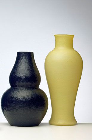 One black vase on the left. One yellow vase on the right.
