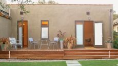 Modern home with decked area leading onto the backyard to support a guide on how to clean decking 