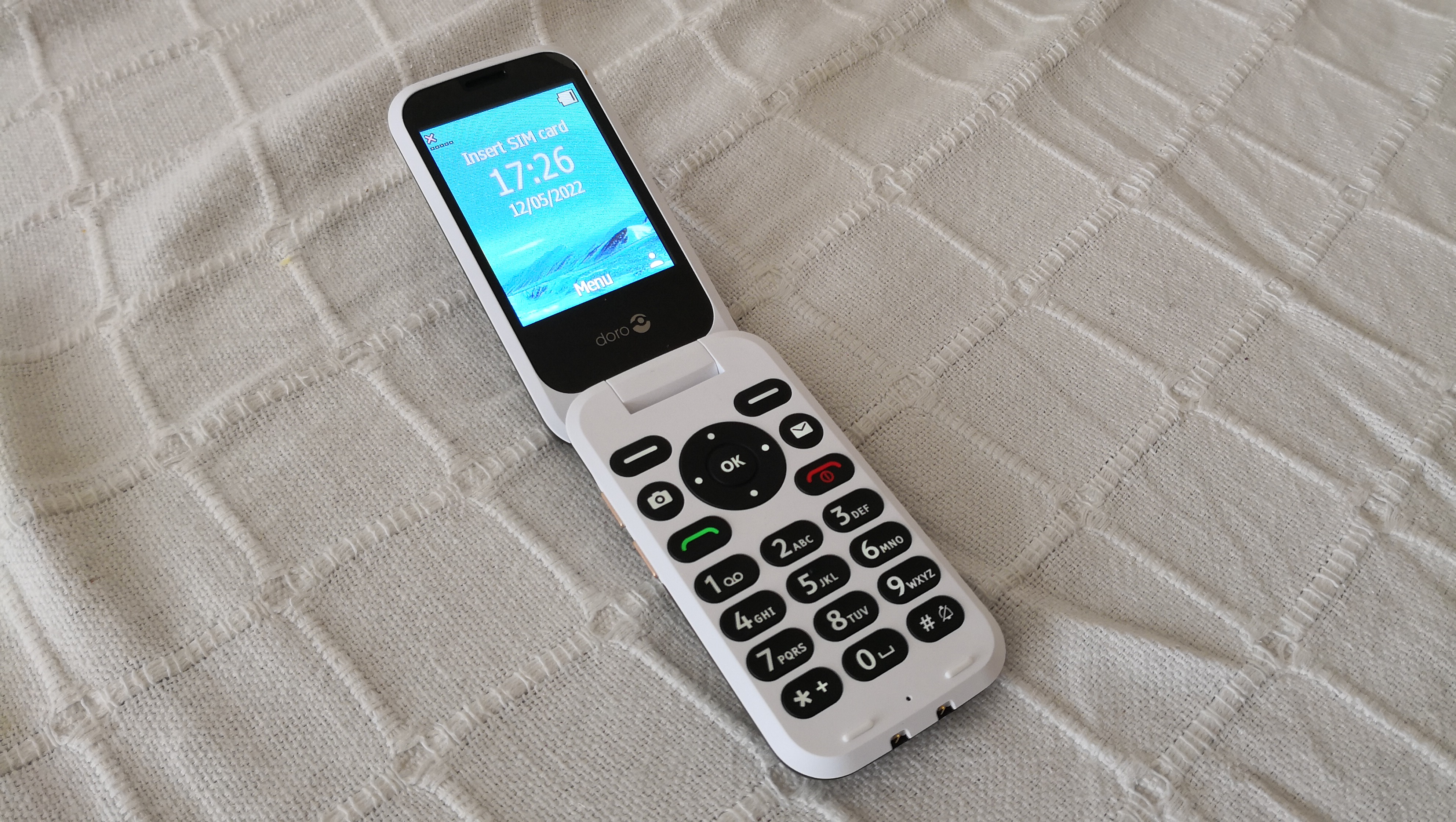 En hvid Doro-mobil åben på en hvid dug.
