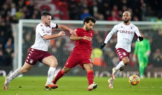 Liverpool’s Mohamed Salah (centre) and Aston Villa’s John McGinn battle for the ball during the Premier League match at Anfield, Liverpool. Picture date: Saturday December 11, 2021