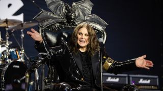 Ozzy Osbourne smiling while sat in a black throne on stage