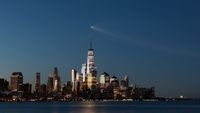 A SpaceX Falcon 9 rocket on mission Starlink Group 10-49 passes by lower Manhattan and One World Trade Center just before dawn in New York City after launching from Cape Canaveral, Florida on Aug. 25, 2026, as seen from Hoboken, New Jersey.