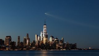 A SpaceX Falcon 9 rocket on mission Starlink Group 10-49 passes by lower Manhattan and One World Trade Center just before dawn in New York City after launching from Cape Canaveral, Florida on Aug. 25, 2026, as seen from Hoboken, New Jersey.