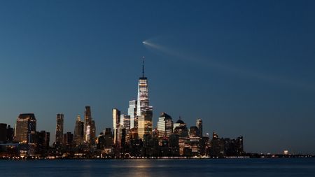 A SpaceX Falcon 9 rocket on mission Starlink Group 10-49 passes by lower Manhattan and One World Trade Center just before dawn in New York City after launching from Cape Canaveral, Florida on Aug. 25, 2026, as seen from Hoboken, New Jersey.