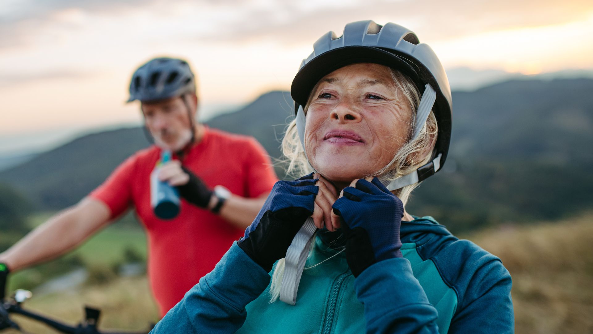 Woman tightening helmet under chin
