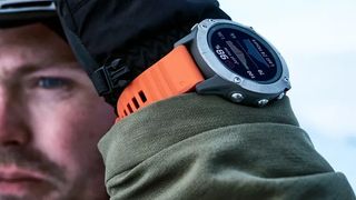 Man wearing Garmin FEnix 6 watch with orange strap