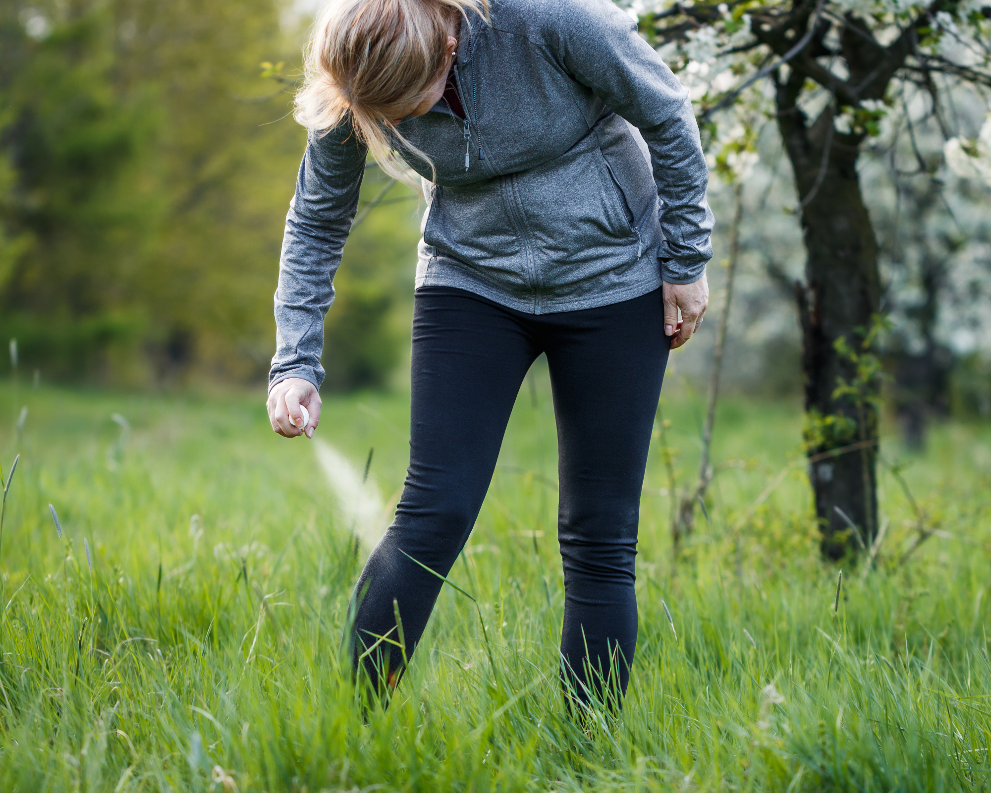 Woman spraying herself with insect repellent