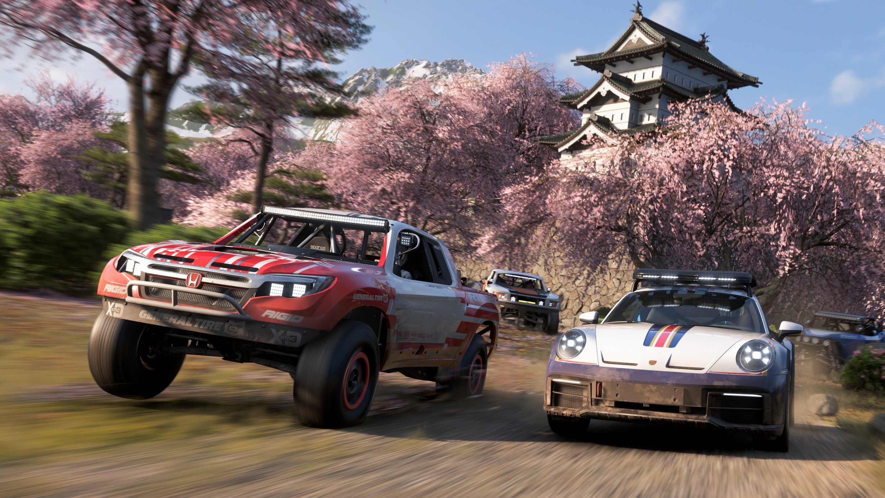 A screenshot of cars racing amidst a grove of cherry blossom trees in Forza Horizon 6.