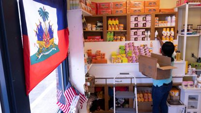 Haitian-American Philomene Philostin stocks the shelves of her store in Springfield, Ohio.