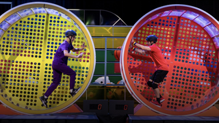 Two contestants in giant hamster wheels in Human vs Hamster