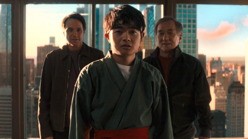 Ben Wang&#039;s Li Fong standing in the middle with Ralph Macchio and Jackie Chan behind him with NYC behind them in Karate Kid: Legends