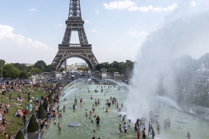 Powerful water jets of the Fontaine du Trocadéro spray Parisians in front of the under which Parisians cool off with the Eiffel Tower in the background, while Paris and France as a whole have been going EIffel Tower on July 25, 2019, now the hottest day