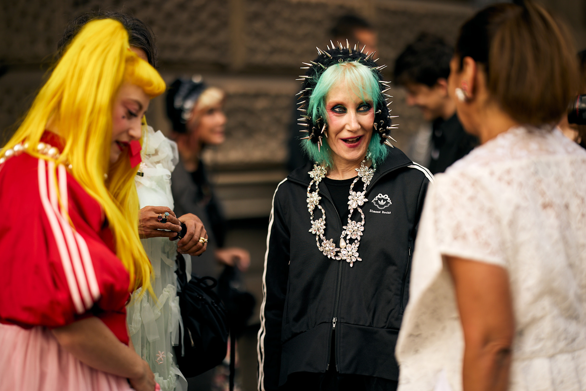 three older woman with wildly colored hair in black jackets on the streets of London