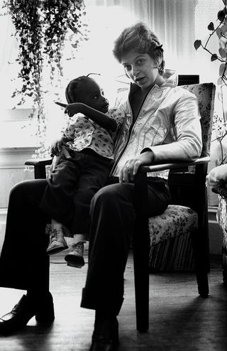 A woman sitting in a chair with a child on her lap