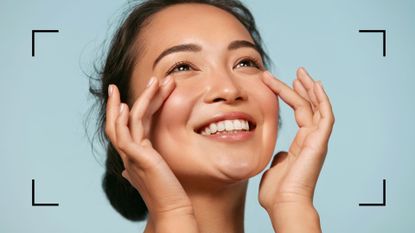 How to cover acne with makeup as shown by a model smiling with natural makeup on a blue background