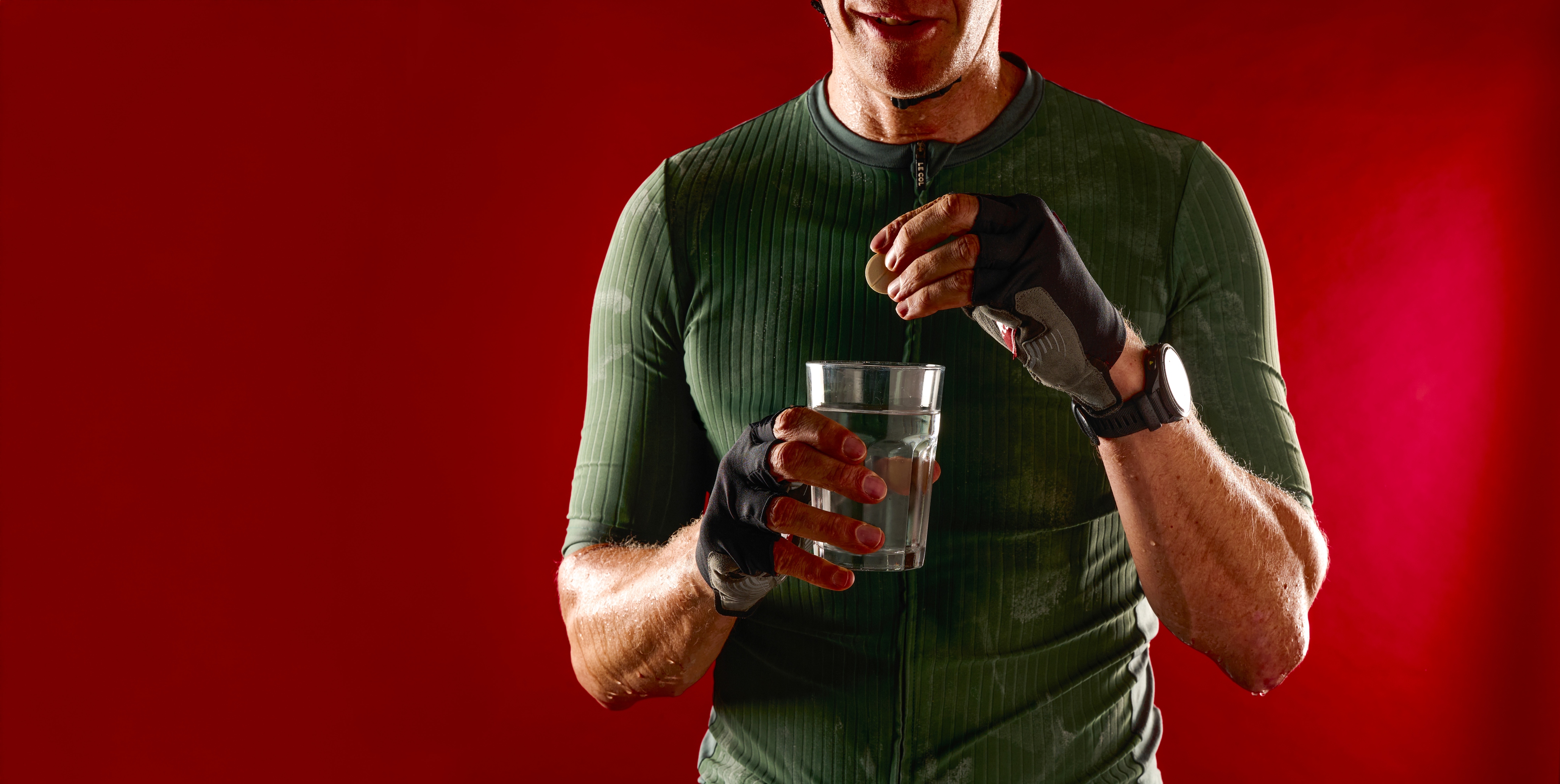 Cyclist puts an electrolyte tab into a glass of water
