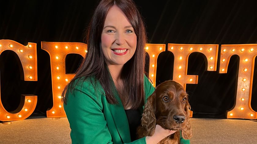 Laura Crombie with a setter in front of a light-up Crufts sign