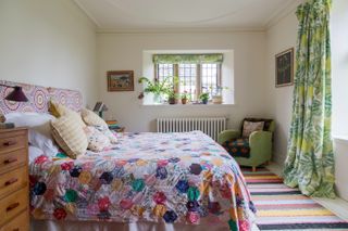 bright patchwork quilt and headboard in bedroom in Jacobean manor