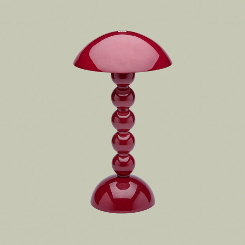 A red table lamp with a bobbin style base