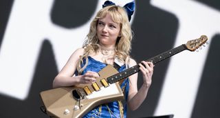 Emily Roberts of the Last Dinner Party playing an Ernie Ball Music Man St. Vincent Goldie, onstage at Glastonbury 2024