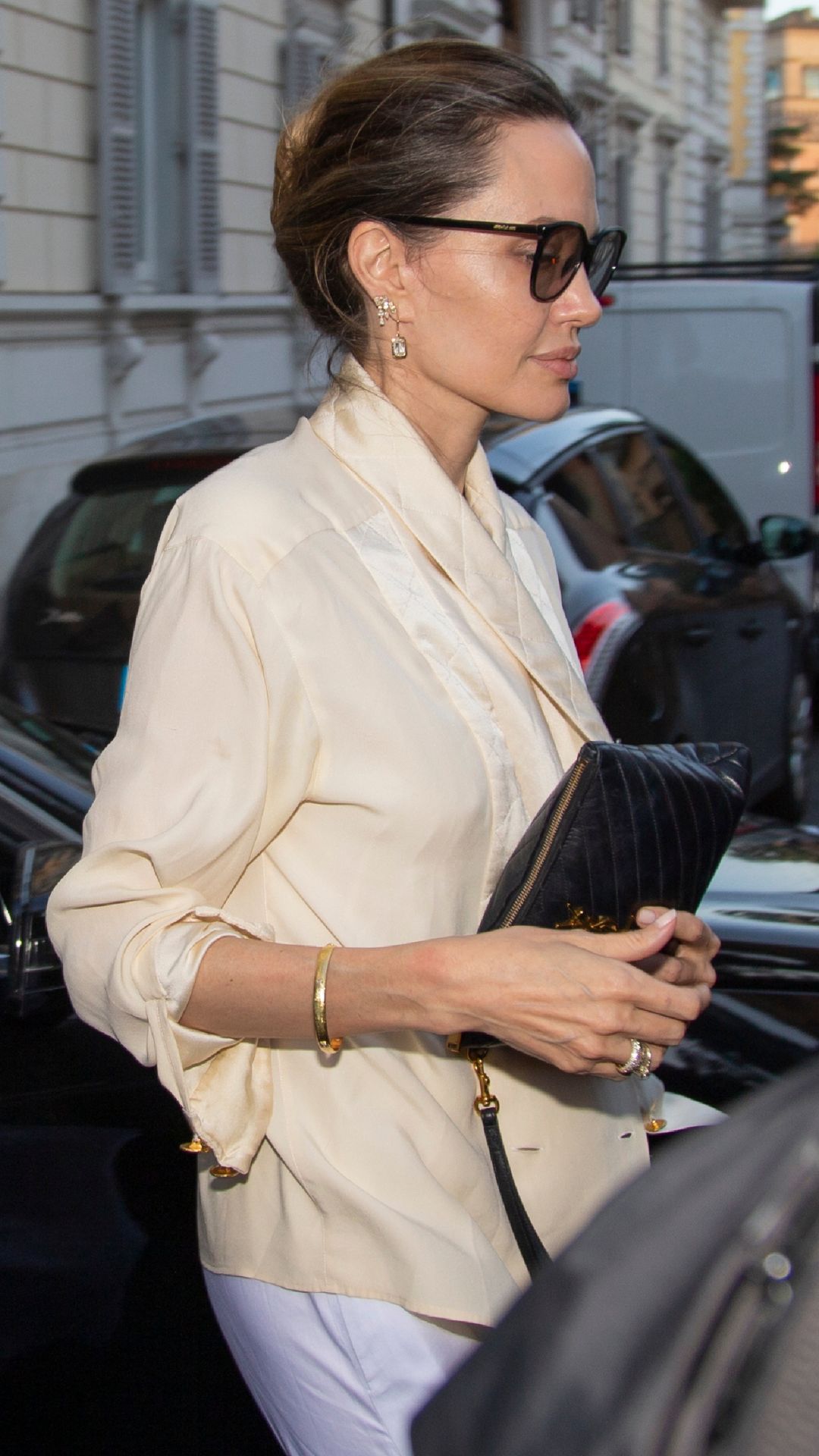 Who made Angelina Jolie's white handbag and black sunglasses