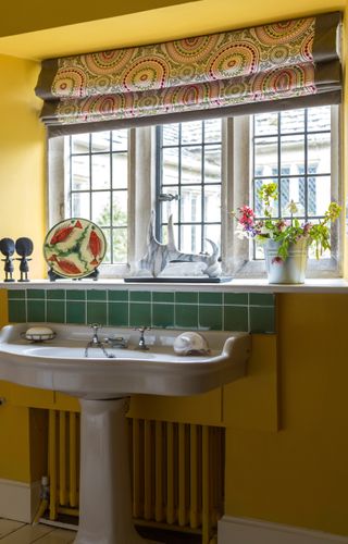 bright bathroom in Jacobean manor with yellow walls and green tiles