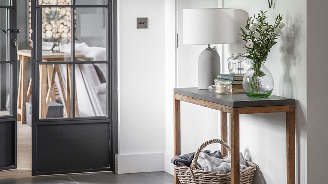 Concrete lampshade in hallway by Cox and Cox with wicker basket and console table 