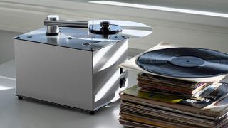 Pro-Ject VC-E record cleaning machine with a stack of LPs