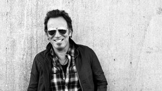 Bruce Springsteen standing against a wall