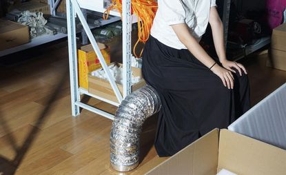 A woman sitting on a metal pipe