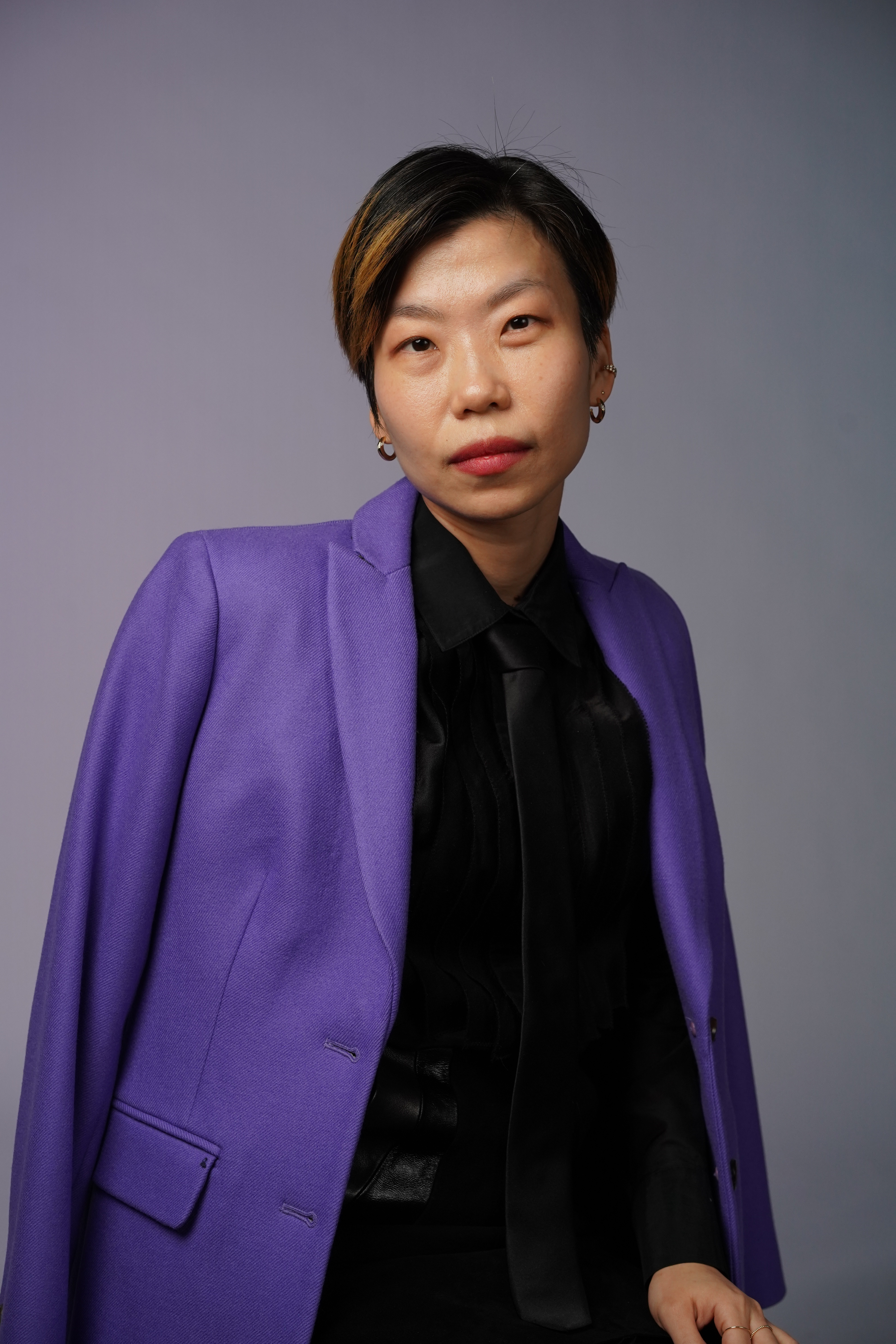 woman with short cropped hair and a purple jacket
