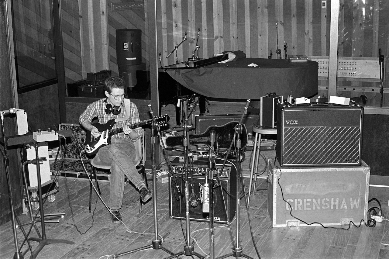 Marshall Crenshaw in the studio, playing his Epiphone Coronet through what appears to be a Carvin X-100 tube combo, as his Vox AC30 sits nearby