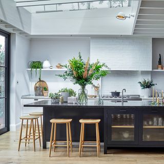 White kitchen with black island and bar stools