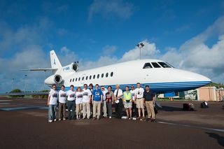 Eclipse chasers, including photographer Ben Cooper at far left, pose for a group photo with their chartered jet to chase the total solar eclipse of 2013 on Nov. 3 during the rare annular/total solar eclipse.