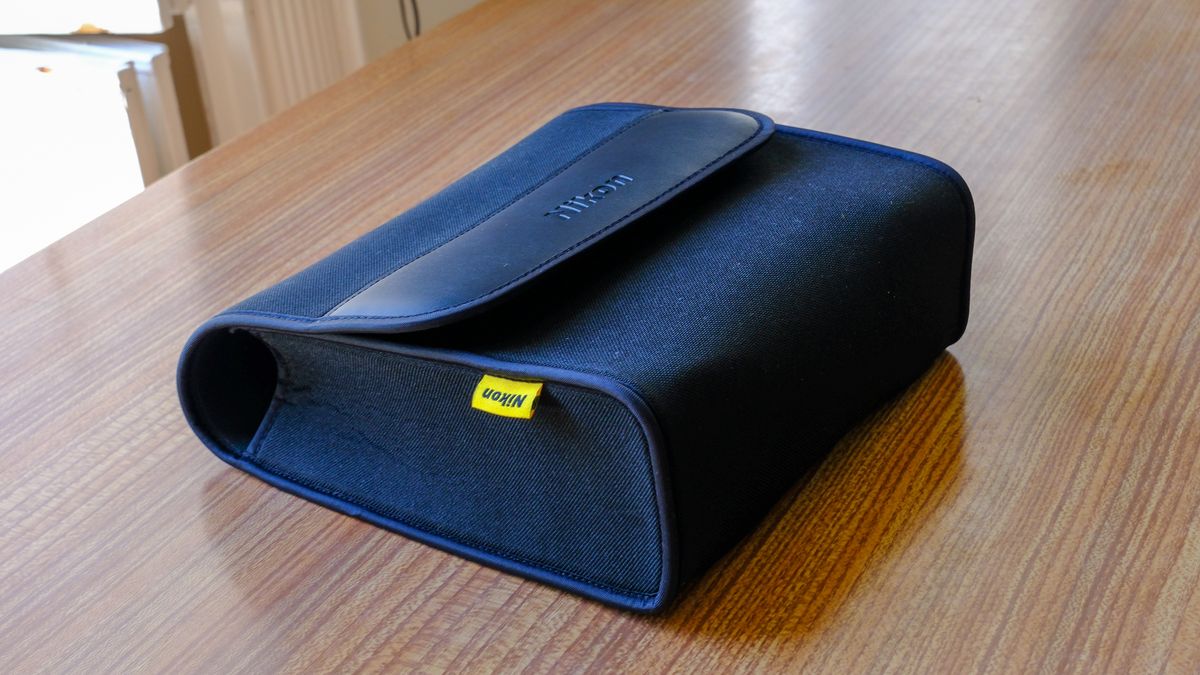 The soft carry case for the Nikon Action Zoom 10-22x50 binoculars lying flat on a wooden table.