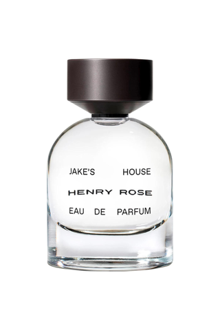 a bottle of henry rose perfume in front of a plain backdrop