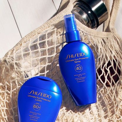 Shiseido sunscreens laying on a beach bag