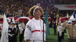 Naomi Ackie sings the Star Spangled Banner on the football field in I Wanna Dance With Somebody.